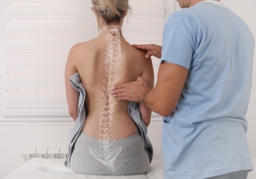 Chiropractor performing scoliosis assessment