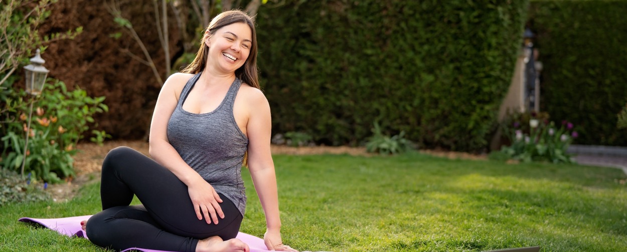Laughing woman doing yoga outdoors