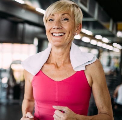 Smiling woman jogging on treadmill