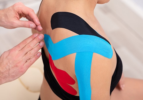 Chiropractor placing rock tape to reduce swelling and inflammation