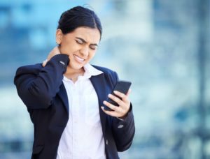 woman texting with text neck pain