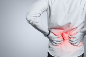 man holding his back with low back pain